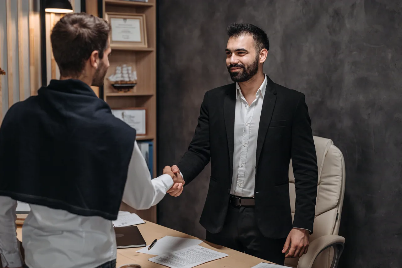 A lawyer smiling across the desk at a client